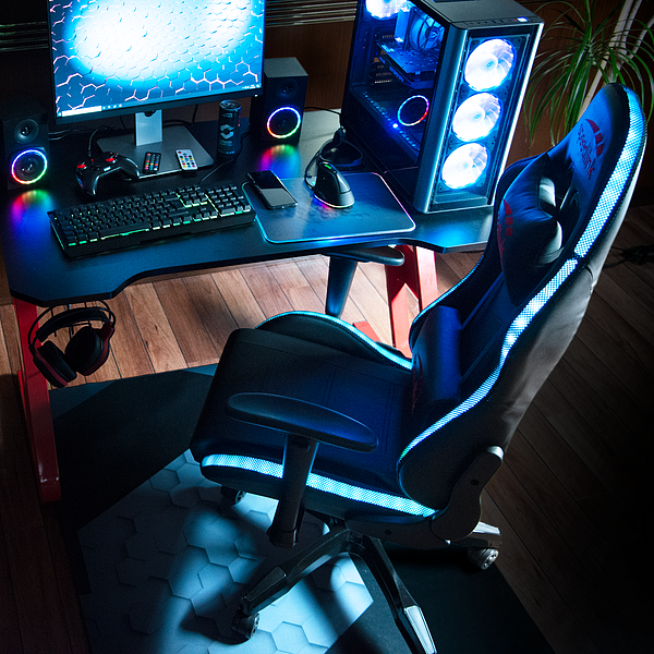 Gaming-Schreibtisch mit beleuchtetem Stuhl, Monitor, Tastatur, Maus, Kopfhörer und leistungsstarkem PC mit LED-Beleuchtung
