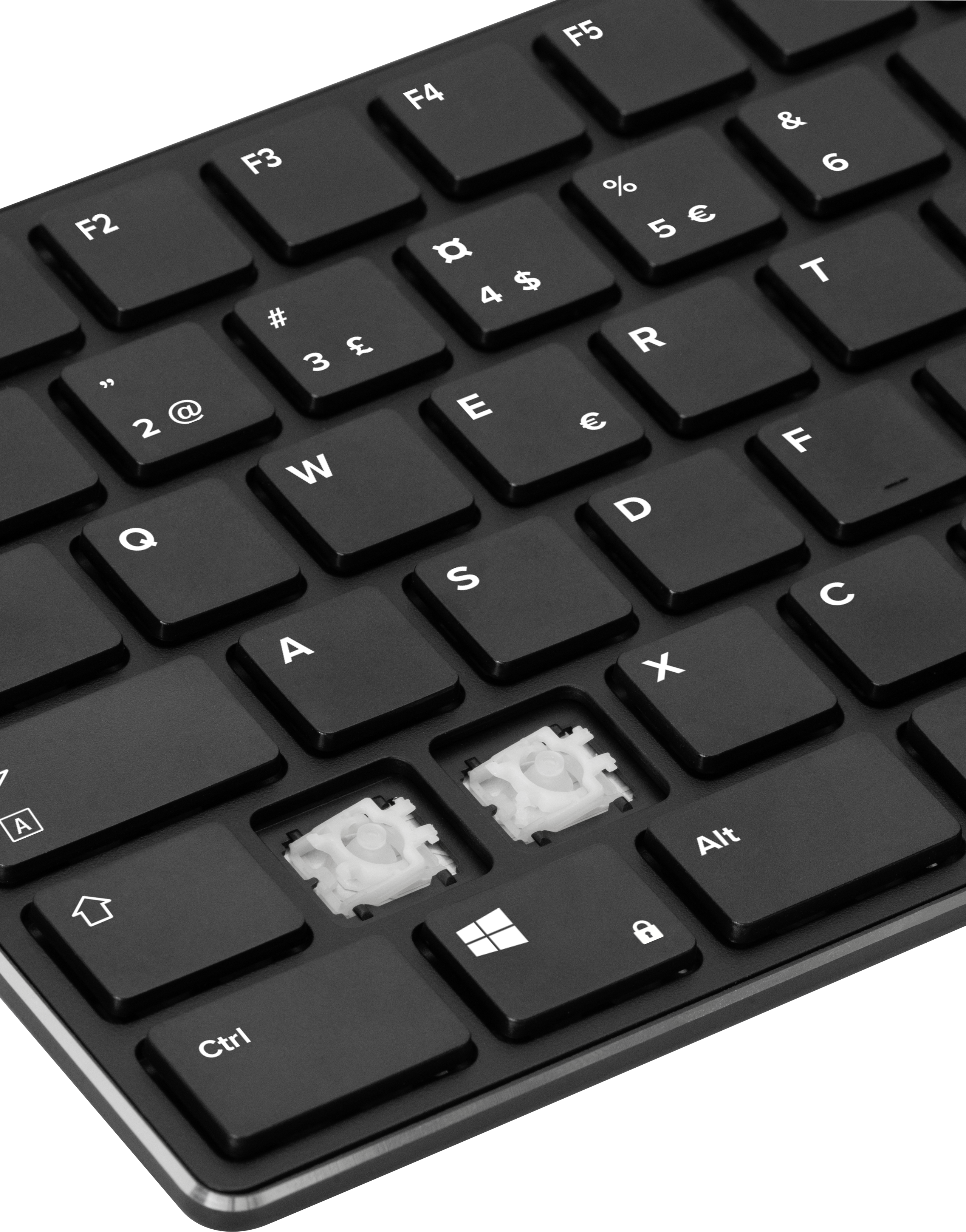 Detailaufnahme einer schwarzen Computertastatur mit zwei fehlenden Tasten, die die darunterliegenden Schalter zeigt